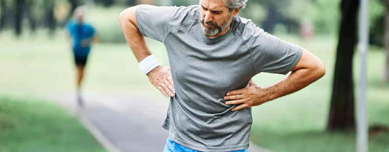 A man with back pain in a park